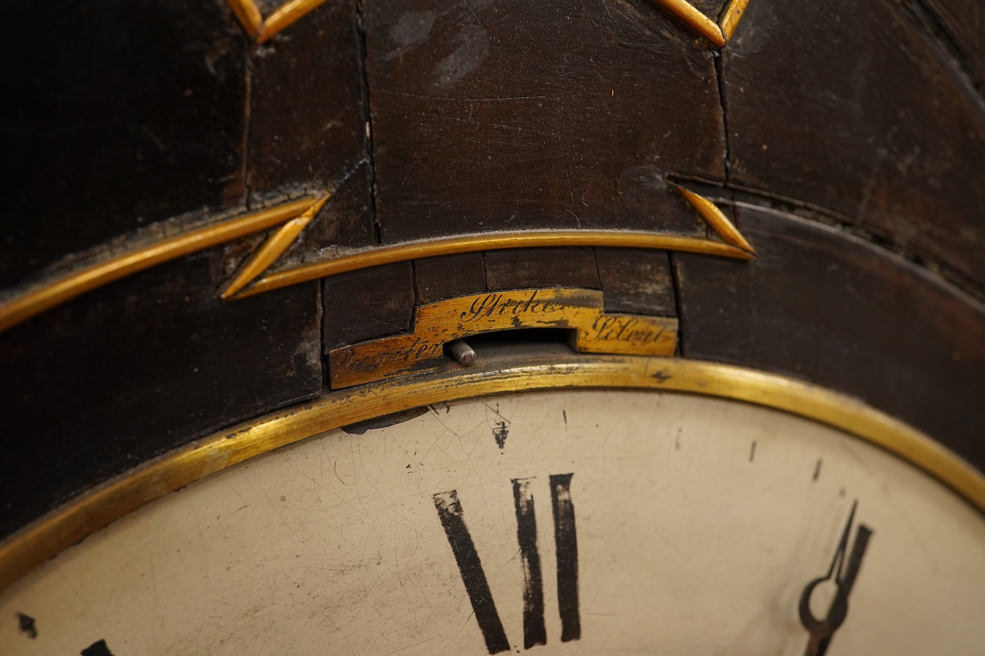 A Regency ebonised and brass inlaid lancet-shape bracket clock, with key and a painted pottery strut timepiece, largest 55cm high (2)